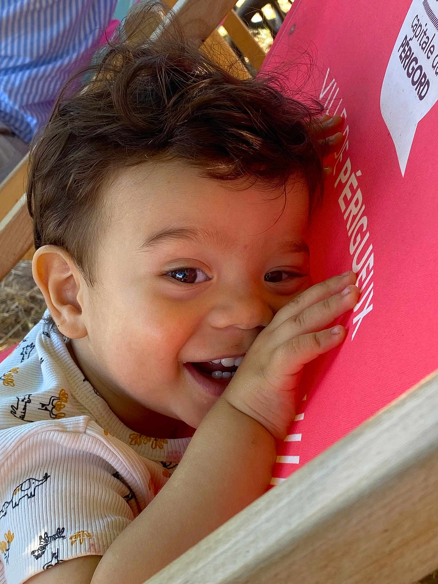 Ahyann-Mathïs a rejoint le concours — aidez-le/la à gagner de superbes lots ! baby, cheerful, child, closeup, clothing, cute, expression, eyes, face, hair, hand, happy, indoors, person, playful, portrait, red_surface, smile, toddler, wood