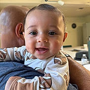 Roman joined the competition — help win amazing prizes! baby, child, smiling, face, infant, person, clothing, onesie, football_pattern, adult, bald_head, arm, indoor, happy, holding, closeup, cute, portrait, young, love