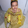 child, princess, crown, yellow_dress, gloves, smiling, indoor, happy, face, costume, playful, footwear, shoe, fashion, portrait, cute, young, celebration, dress_up, fun