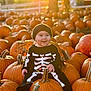 baby, child, pumpkin, pumpkin_patch, autumn, fall, outdoor, smiling, black_clothing, hat, cute, seasonal, holiday, nature, sunlight, orange, festive, skeleton_costume, happy, sitting