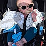 Romy a rejoint le concours — aidez-le/la à gagner de superbes lots ! baby, blanket, blue_toy, child, clothing, cute, footwear, hand_gesture, infant, outdoor, pacifier, peace_sign, person, relaxing, seat, shadow, stroller, sunglasses, sunlight, toy