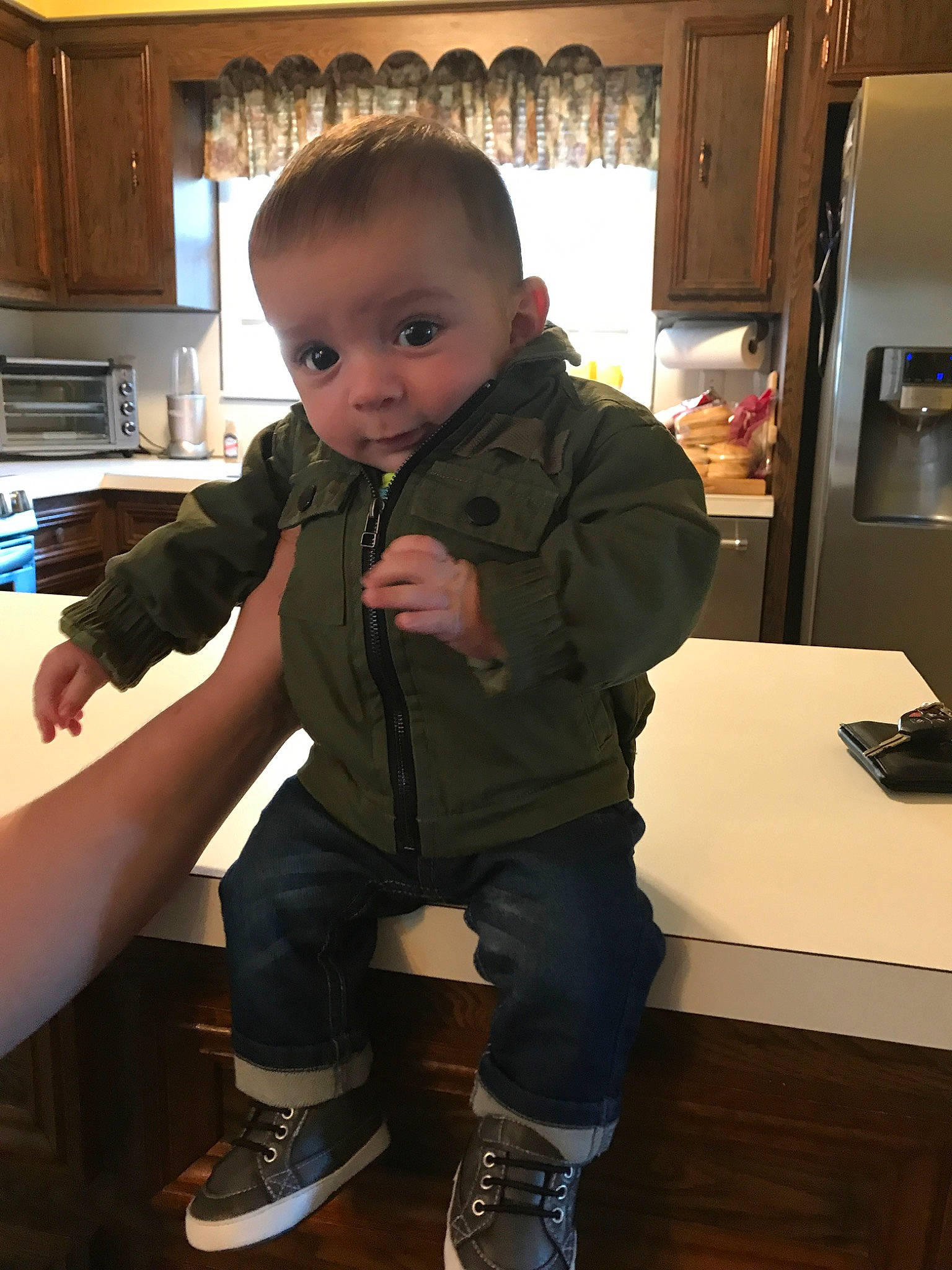 Danny is registered to the contest to win money with this photo: arm, baby, child, jacket, outerwear, person, shoe, standing, toddler