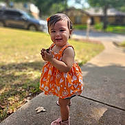Everly joined the competition — help win amazing prizes! toddler, child, orange_dress, smiling, outdoor, sidewalk, grass, trees, sunlight, pink_shoes, happy, portrait, young_child, person, nature, daylight, flower_pattern, earrings, hair_bow, blurred_background