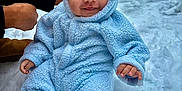 Grayson is registered to the contest to win money with this photo: baby, child, snow, winter, blue_onesie, fuzzy_clothing, cute, smile, outdoor, cold_weather, person, infant, hood, ears, snowy_background, happy, warm_clothing, small_hand, sitting, portrait