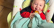 Mayden participe au concours pour gagner de l'argent avec cette photo : baby, blanket, bottle, child, smiling, indoor, baby_chair, floor, toy, tricycle, soccer_ball, red_clothing, blue_blanket, happy, person, infant, seat, tiled_floor, cute, cozy