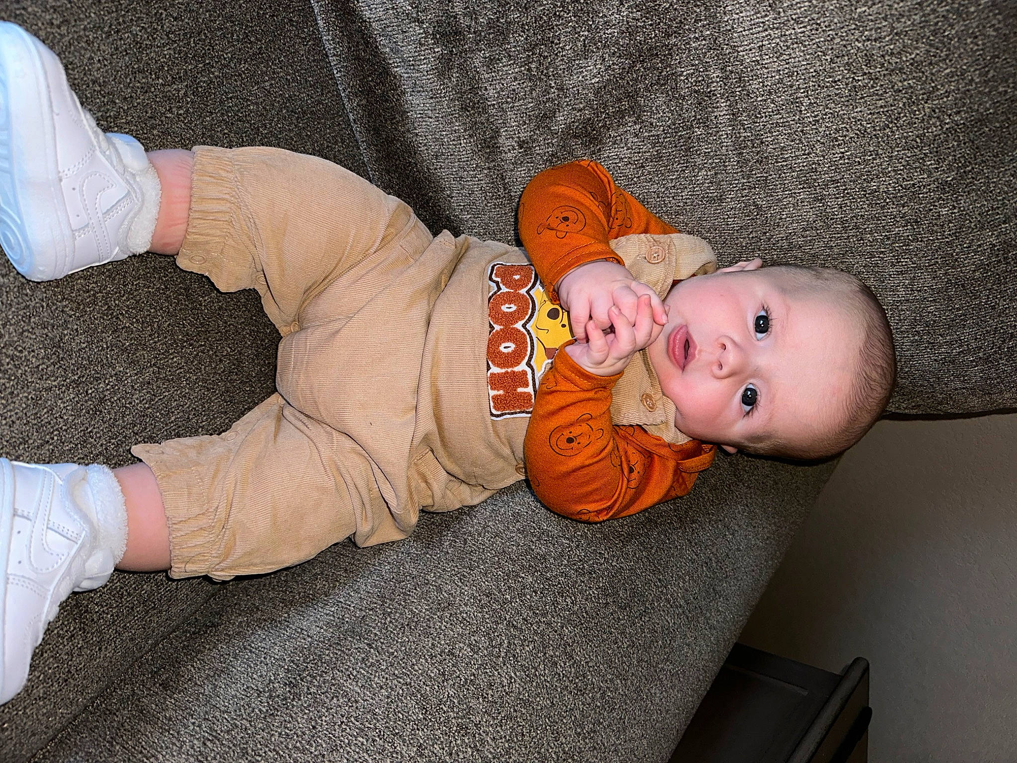 Aiden is registered to the contest to win money with this photo: baby, baby_products, baby_safety, baby_sleeping, baby_toddler_clothing, child, comfort, flooring, human_body, linens, orange, person, room, sitting, sleeve, toddler, wood