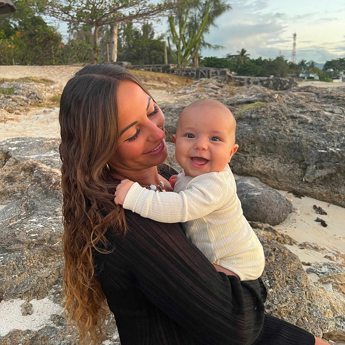 Liano participe au concours pour gagner de l'argent avec cette photo : baby, beach, casual, clothing, family, grass, happy, holding, landscape, nature, outdoor, person, portrait, rock, sand, sky, smile, sunset, tree, woman