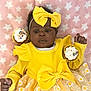 baby, child, yellow_dress, bow, headband, cupcake, sprinkles, blanket, stars, pink_background, smiling, cute, infant, tutu_skirt, floral_pattern, celebration, sweet, happy, soft_texture, portrait