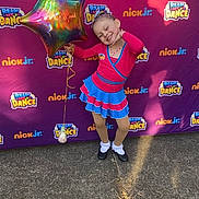 Kalina is registered to the contest to win money with this photo: child, girl, balloon, star_balloon, dance_costume, smiling, posing, outdoor, sidewalk, colorful_background, logo, ready_set_dance, nick_jr, happy, festival, celebration, party, ribbon, footwear, fun