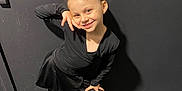 Kalina is registered to the contest to win money with this photo: child, girl, smile, pose, black_clothing, bow, wall, carpet, footwear, happy, indoors, dancewear, long_sleeves, leggings, portrait, standing, young, cute, fashion, playful