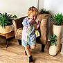 Jasper is registered to the contest to win money with this photo: child, boy, colorful_shirt, shorts, socks, indoor, armchair, wooden_floor, plants, greenery, pot_plants, curly_hair, happy, cute, casual_clothing, home_interior, portrait, natural_light, smiling, playful