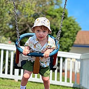Jasper joined the competition — help win amazing prizes! toddler, child, swing, playground, hat, bucket_hat, shirt, animal_print, shorts, shoes, socks, outdoor, grass, fence, daylight, summer, play, fun, portrait, park