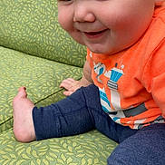 Gunnar joined the competition — help win amazing prizes! baby, child, infant, smiling, happy, sitting, portrait, face, eyes, bare_feet, orange_shirt, blue_pants, clothing, chair, upholstery, indoors, close_up, playful, cute, photography