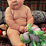 Gunnar joined the competition — help win amazing prizes! baby, child, infant, sitting, portrait, face, serious_expression, indoor, couch, blanket, plaid, stuffed_animals, toys, colorful, home, furniture, bare_skin, playtime, close_up, photography