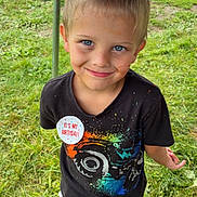 Don joined the competition — help win amazing prizes! child, boy, birthday, outdoor, grass, smiling, face, blue_eyes, black_tshirt, colorful_print, pants, shoes, dirt, playful, celebration, badge, standing, casual_clothing, daylight, fun