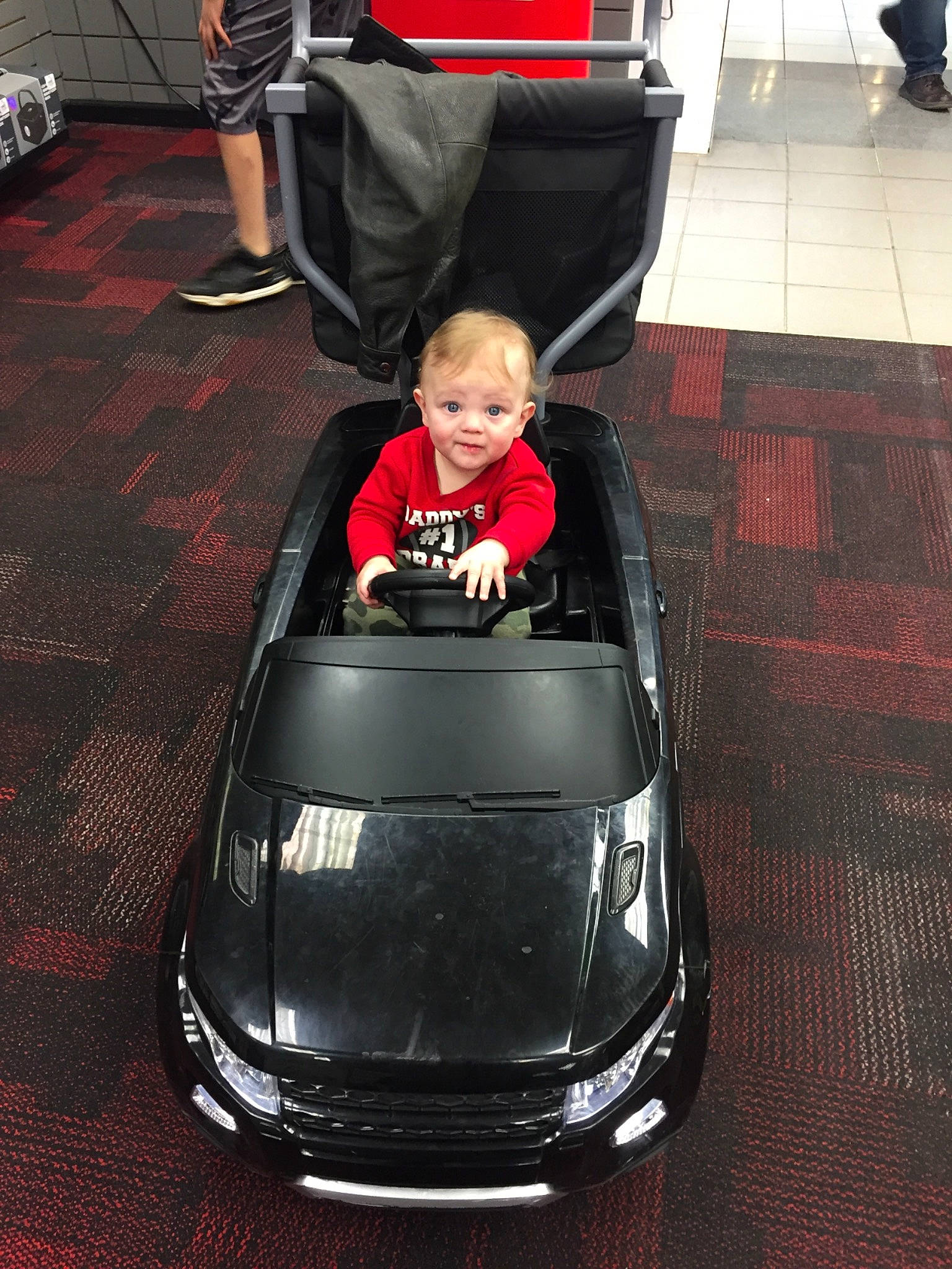 Don is registered to the contest to win money with this photo: automotive_design, automotive_exterior, automotive_lighting, automotive_tire, black, bumper, car, chair, fender, grille, hood, jacket, motor_vehicle, person, personal_luxury_car, rim, smile, tire, toddler, vehicle