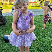 Bella is registered to the contest to win money with this photo: child, girl, boy, dress, purple, smile, play, grass, outdoor, sunny, suburb, tree, house, sidewalk, barefoot, footwear, happy, summer, kid, fun