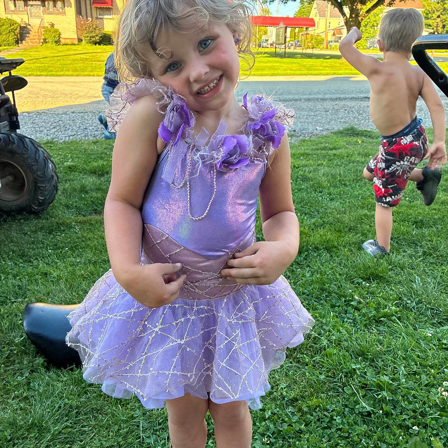 Bella is registered to the contest to win money with this photo: child, girl, boy, dress, purple, smile, play, grass, outdoor, sunny, suburb, tree, house, sidewalk, barefoot, footwear, happy, summer, kid, fun