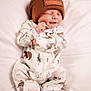 baby, newborn, sleeping, beanie, hat, onesie, animal_pattern, white_background, soft, cute, peaceful, infant, clothing, resting, child, portrait, cozy, small, smile, hand