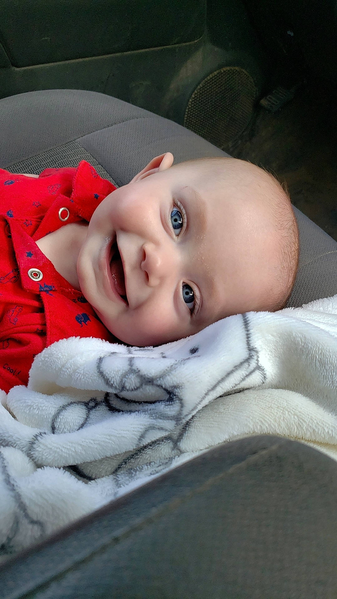Grayson joined the competition — help win amazing prizes! baby, blanket, blue_eyes, car_seat, child, closeup, comfort, cozy, cute, face, happy, head, indoor, infant, portrait, red_clothing, smiling, soft_texture, wrapped, young_child