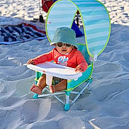 Adrian is registered to the contest to win money with this photo: baby, child, beach, sand, sunshade, hat, sunglasses, chair, outdoor, summer, sun_protection, footwear, infant, toy_cart, blanket, relaxation, sunny, vacation, casual_clothing, playtime