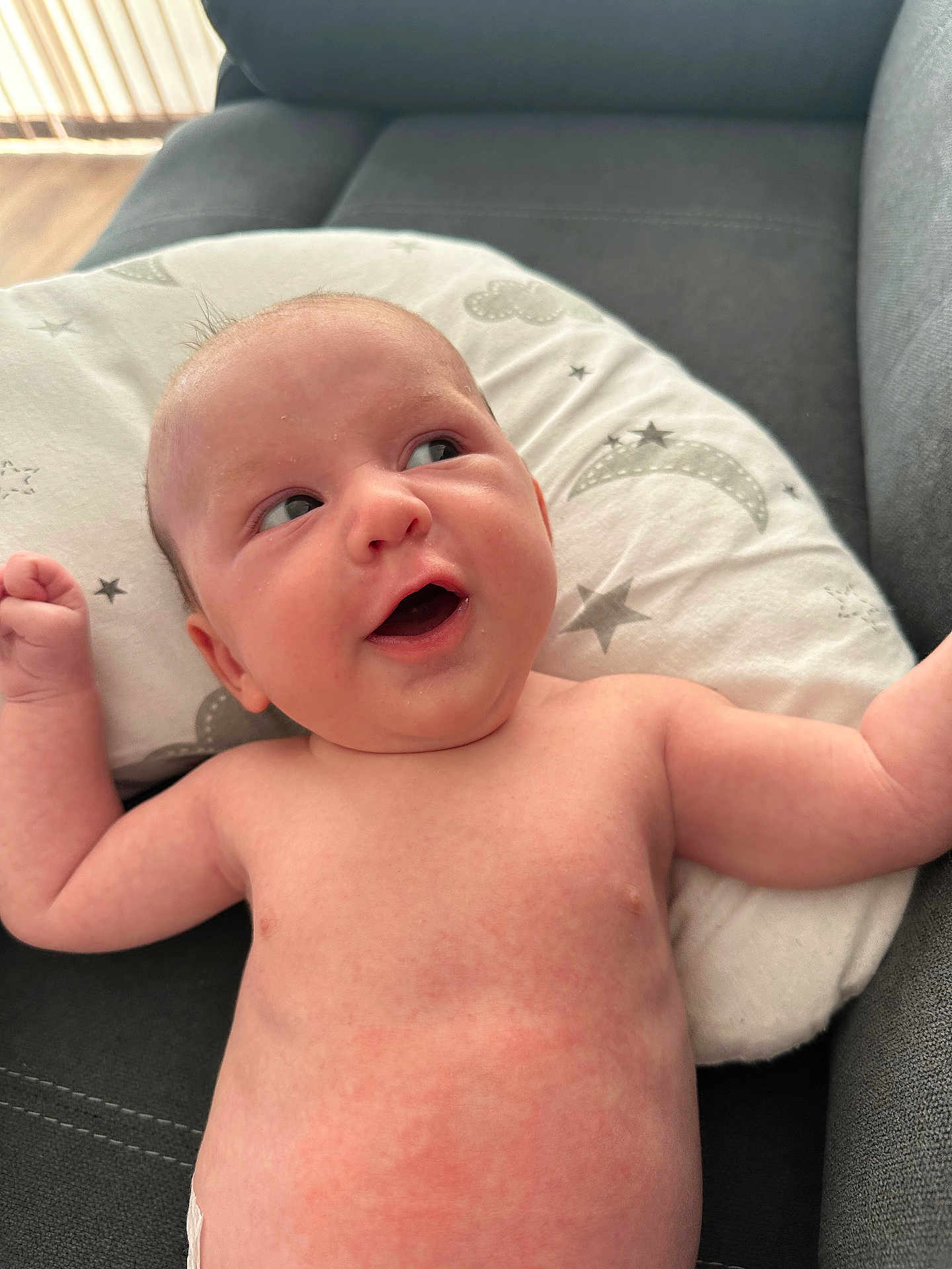 Brennus is registered to the contest to win money with this photo: baby, infant, skin, face, expression, pillow, stars, moon, couch, arm, chubby, curious, indoors, light, natural_light, resting, cute, young, human, portrait