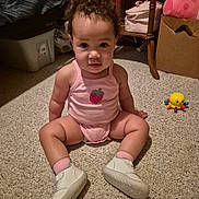 Gracelyn is registered to the contest to win money with this photo: baby, child, pink_outfit, strawberry, carpet, toy, yellow_toy, indoor, curly_hair, white_shoes, sitting, floor, furniture, box, table, cute, portrait, young_child, home, curious