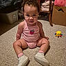 baby, child, pink_outfit, strawberry, carpet, toy, yellow_toy, indoor, curly_hair, white_shoes, sitting, floor, furniture, box, table, cute, portrait, young_child, home, curious