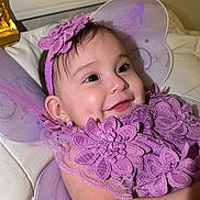 Stefany joined the competition — help win amazing prizes! baby, infant, purple, lace, flower, headband, wings, smile, happy, closeup, face, child, costume, fairy, cute, portrait, lying_down, soft, indoors, toddler