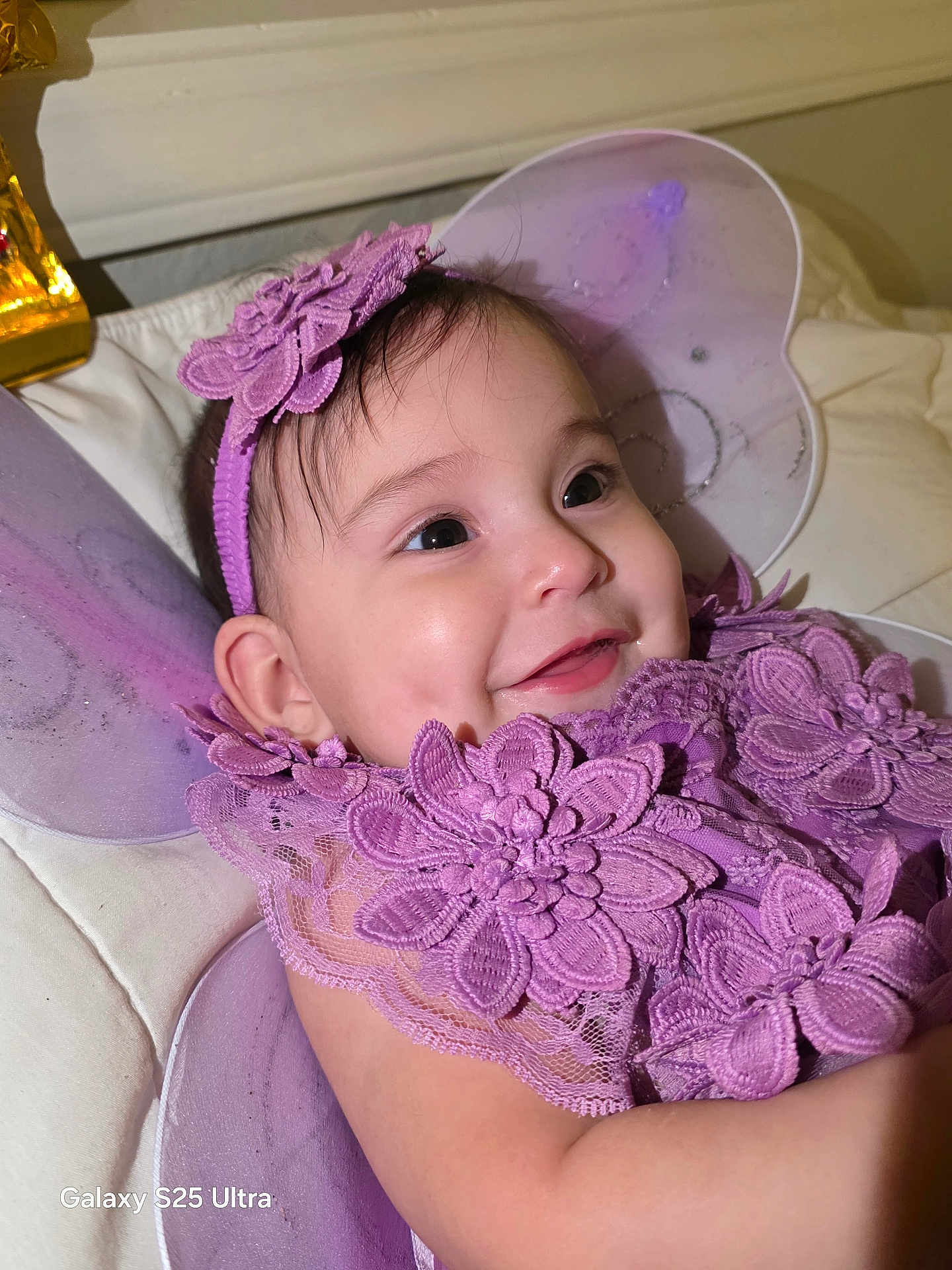 Stefany joined the competition — help win amazing prizes! baby, infant, purple, lace, flower, headband, wings, smile, happy, closeup, face, child, costume, fairy, cute, portrait, lying_down, soft, indoors, toddler