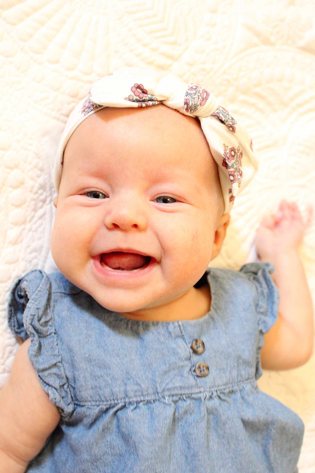 Daisy Mae joined the competition — help win amazing prizes! baby, smiling, headband, denim_dress, portrait, close_up, infant, happy, cute, child, face, skin, blue_eyes, textile, fabric, button, hand, blanket, soft, indoors