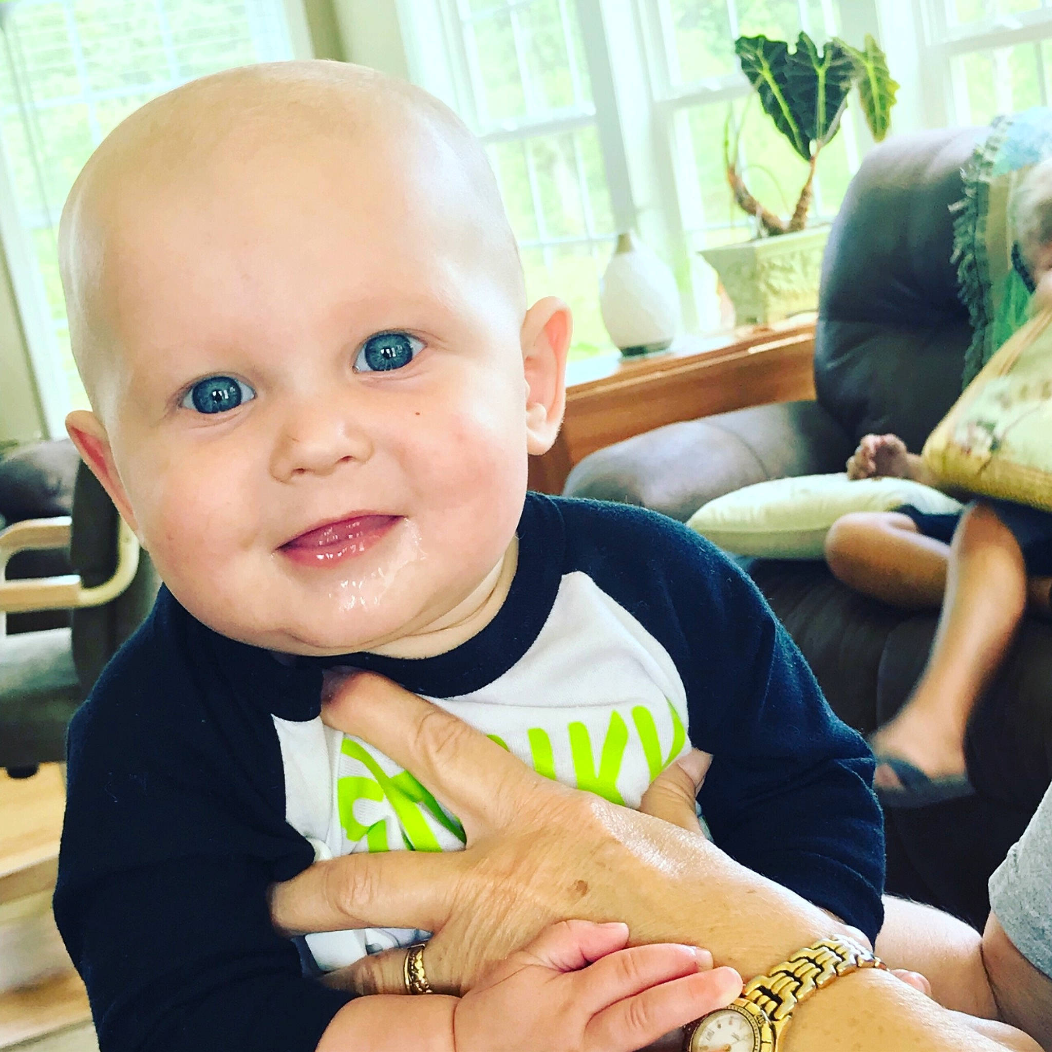 Baker is registered to the contest to win money with this photo: arm, baby, baby_products, child, ear, eye, face, facial_expression, finger, gesture, hand, head, joy, person, play, product, sitting, skin, smile, thumb