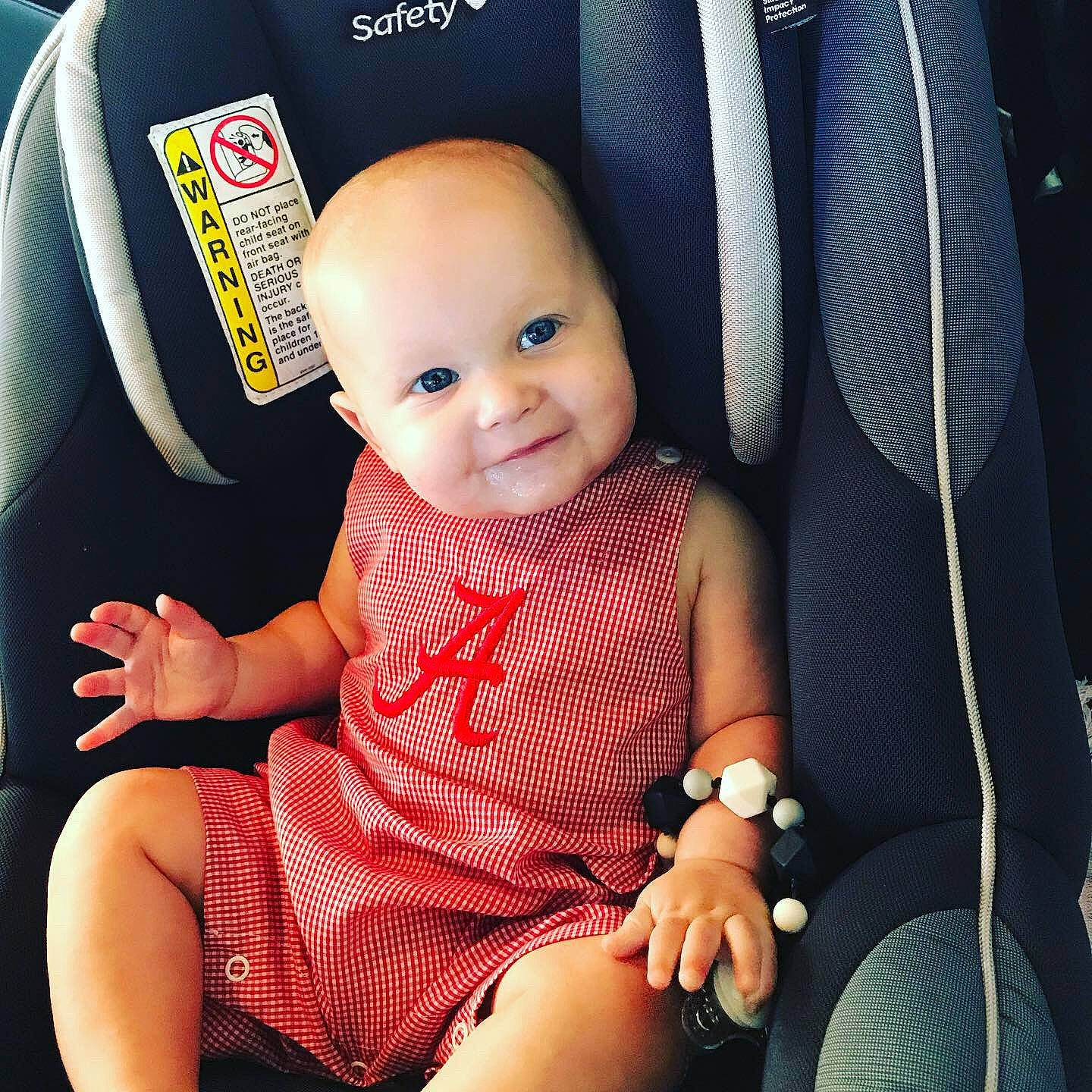 Baker is registered to the contest to win money with this photo: auto_part, baby, baby_carriage, baby_in_car_seat, baby_products, car_seat, car_seat_cover, child, cool, person, product, seat_belt, sitting, skin, smile, toddler