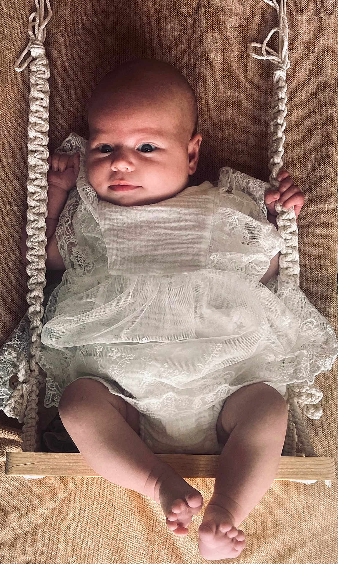 Jade participe au concours pour gagner de l'argent avec cette photo : baby, infant, swing, rope, white_dress, lace, barefoot, cute, child, portrait, hands, legs, feet, texture, fabric, wood, playful, indoors, closeup, cute_face