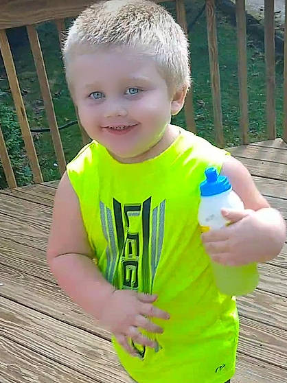 Victor Paul is registered to the contest to win money with this photo: baby_toddler_clothing, bottle, child, finger, fun, gesture, grass, hand, happy, joy, leisure, people_in_nature, person, plastic_bottle, sleeve, smile, summer, t_shirt, thumb, toddler