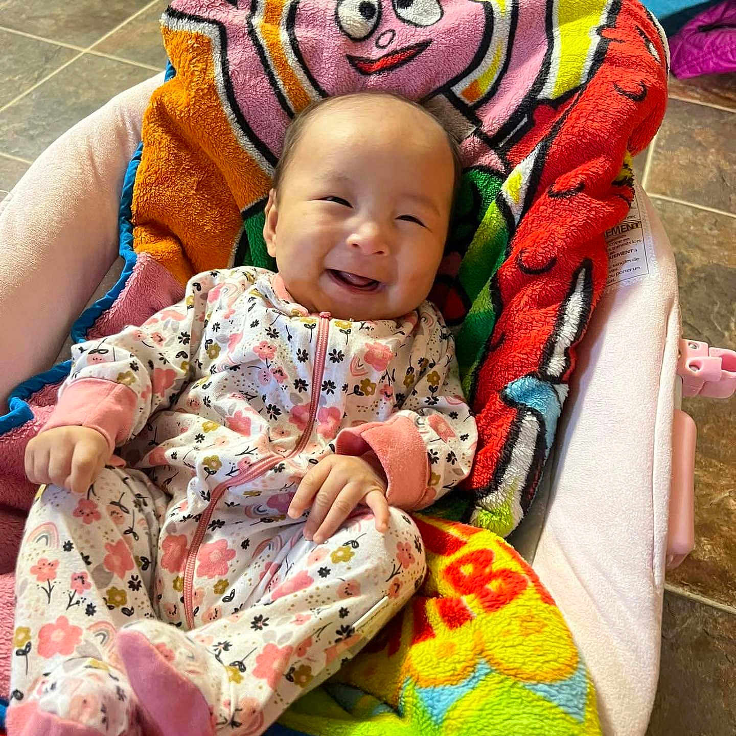 Penelope Reign is registered to the contest to win money with this photo: baby, baby_girl, baby_seat, blanket, child, clothing, colorful, cozy, cute, floor_tiles, floral_pattern, happy, indoors, infant, onesie, person, portrait, relaxing, smiling, soft_toys
