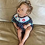 toddler, child, sleeping, couch, leather, polka_dot, navy_blue, outfit, pigtails, hair, bracelet, indoors, relaxing, cute, baby, person, small_child, seated, portrait, peaceful