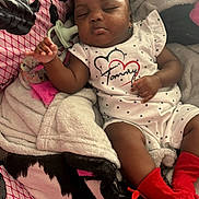 Maddison joined the competition — help win amazing prizes! baby, sleeping, onesie, red_socks, blanket, bedspread, floral_pattern, infant, face, peaceful, resting, indoor, soft_toys, cozy, cushion, person, portrait, home, child, cute