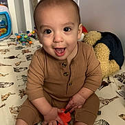Axel joined the competition — help win amazing prizes! baby, child, crib, toy, pajamas, animal_print, smiling, happy, infant, indoors, cute, playtime, face, hand, foot, furniture, bedroom, teddy_bear, colorful, young