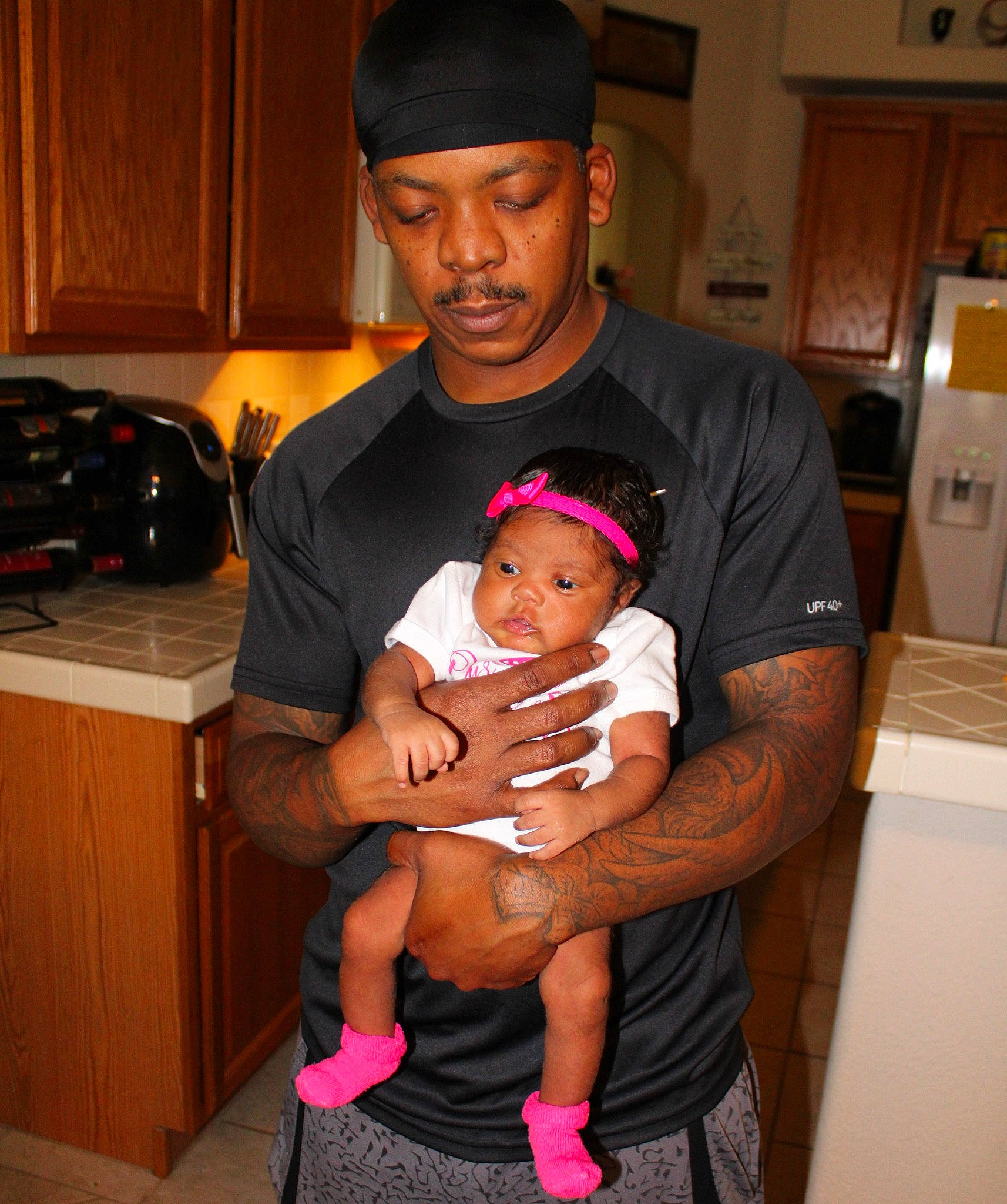 Sapphire is registered to the contest to win money with this photo: abdomen, baby, baseball_cap, black, cabinetry, cap, child, event, fun, happy, headwear, home_appliance, kitchen_appliance, lap, muscle, organ, person, room, shorts, t_shirt