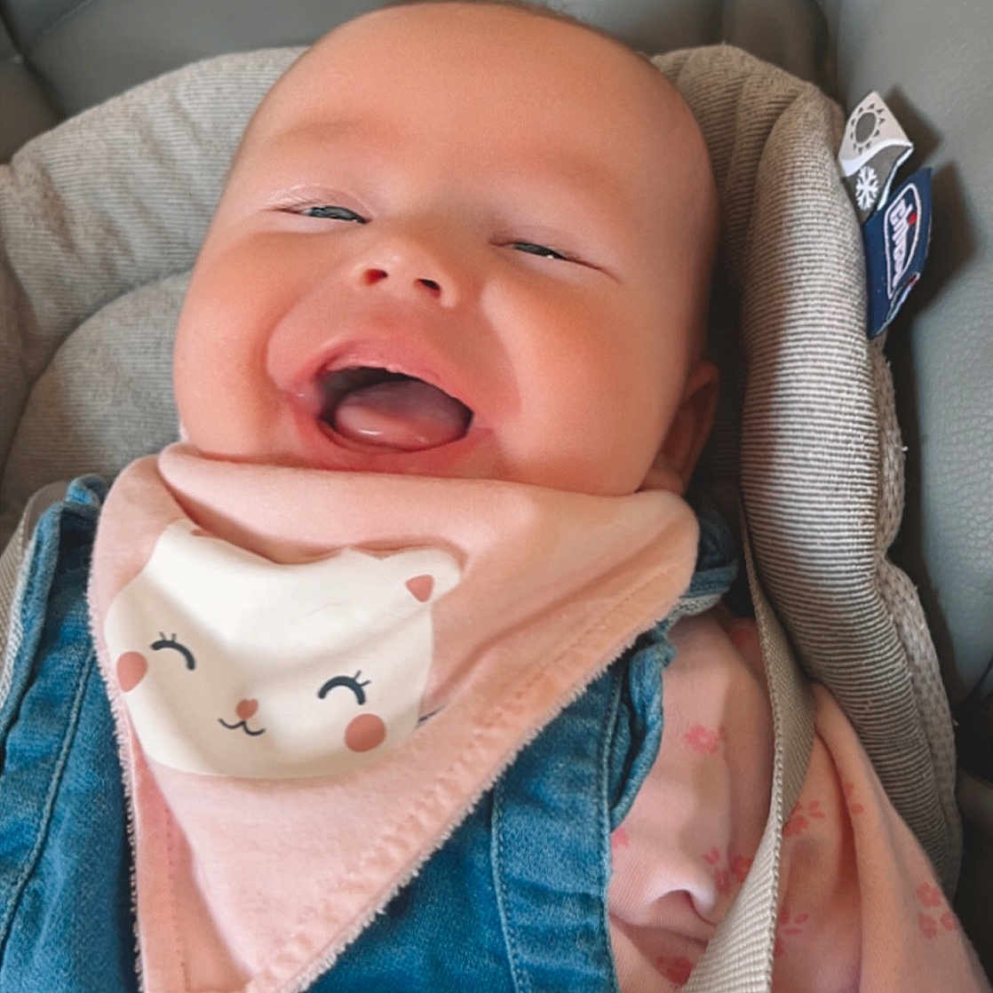Myra participe au concours pour gagner de l'argent avec cette photo : baby, baby_in_car_seat, baby_toddler_clothing, blue, cheek, chin, comfort, face, happy, lip, mouth, neck, nose, pink, seat_belt, skin, sleeve, smile, textile, toddler
