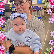 Rose joined the competition — help win amazing prizes! baby, child, person, glasses, cap, store, shopping_cart, floral_frame, pajamas, headband, holding, indoor, casual_clothing, cute, blue_clothing, portrait, shopping, smiling, woman, infant