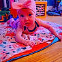 Rose is registered to the contest to win money with this photo: baby, pink_hat, blanket, floor, toy, wooden_floor, tongue_out, playful, indoor, child, curious, colorful, home, furniture, cute, person, sparkle_effect, headwear, infant, crawling