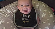 Abbott joined the competition — help win amazing prizes! baby, bib, smile, star_pattern, cushion, toy, pacifier, indoor, child, happy, face, person, furniture, blanket, comfort, infant, clothing, seated, cute, portrait