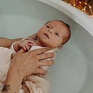 Arthur participe au concours pour gagner de l'argent avec cette photo : newborn, baby, bathtub, water, blanket, hand, tattoo, infant, bath, skin, relaxation, soothing, wrapped, adult_hand, fairy_lights, warmth, care, gentle, peaceful, indoors