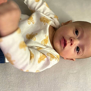 Rome joined the competition — help win amazing prizes! baby, child, clothing, curious, denim, expression, eyes, face, head, indoor, infant, lying_down, mouth, onesie, patterned_clothing, person, portrait, skin, soft_surface, young