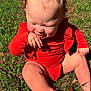 baby, child, grass, outdoor, sunlight, red_clothing, pigtails, cute, smiling, barefoot, infant, nature, happy, sitting, skin, young_child, daylight, playful, portrait, closeup