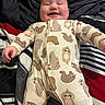 Oliver joined the competition — help win amazing prizes! baby, smiling, infant, onesie, sloth_pattern, sleepwear, bed, blanket, striped, red, black, white, happy, cute, child, person, portrait, lying_down, indoors, cozy