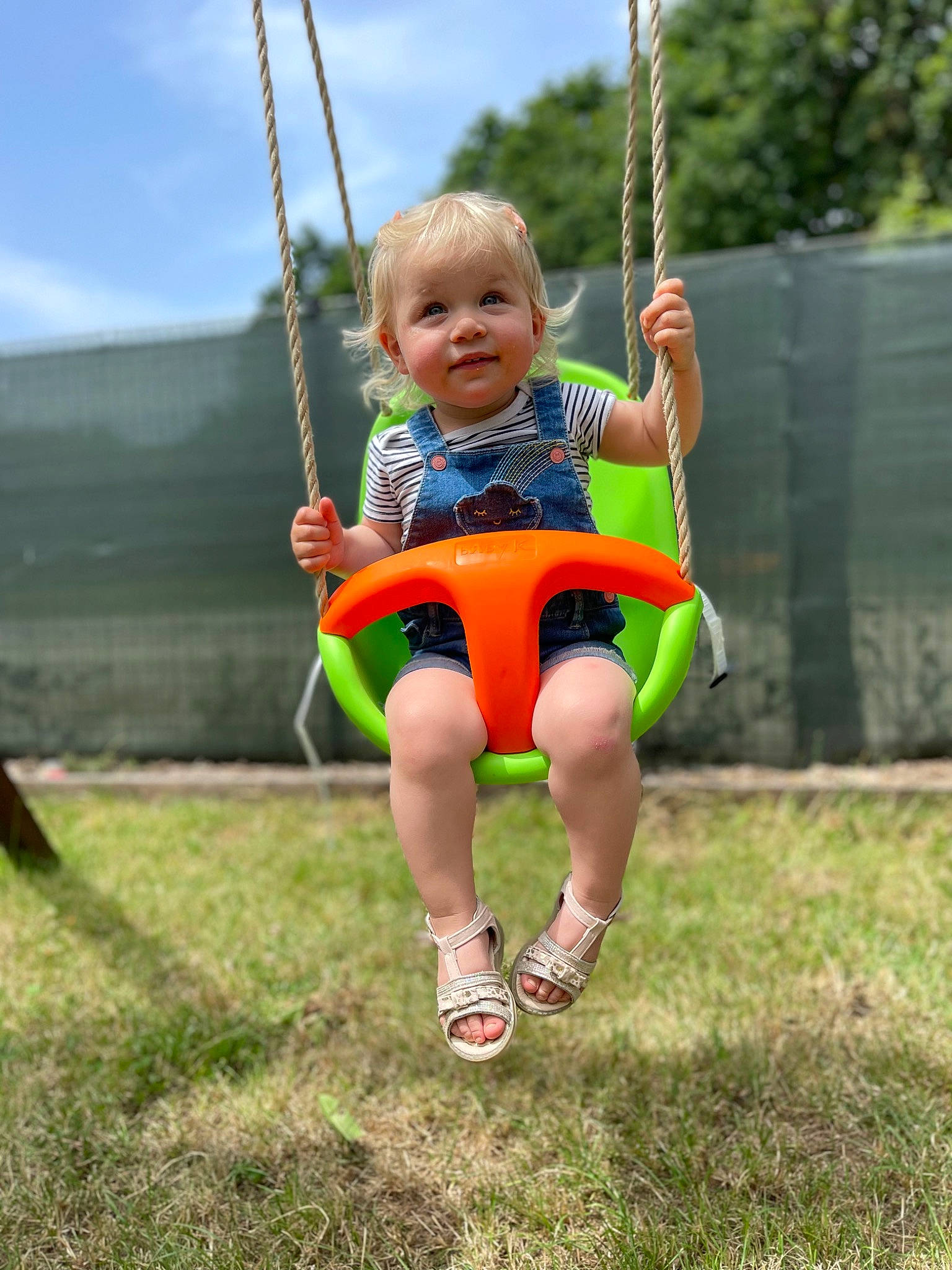 Héloïse a rejoint le concours — aidez-le/la à gagner de superbes lots ! baby, baby_toddler_clothing, child, city, face, fun, grass, happy, human_body, leisure, people_in_nature, person, plant, playground, recreation, shorts, sky, smile, swing, toddler