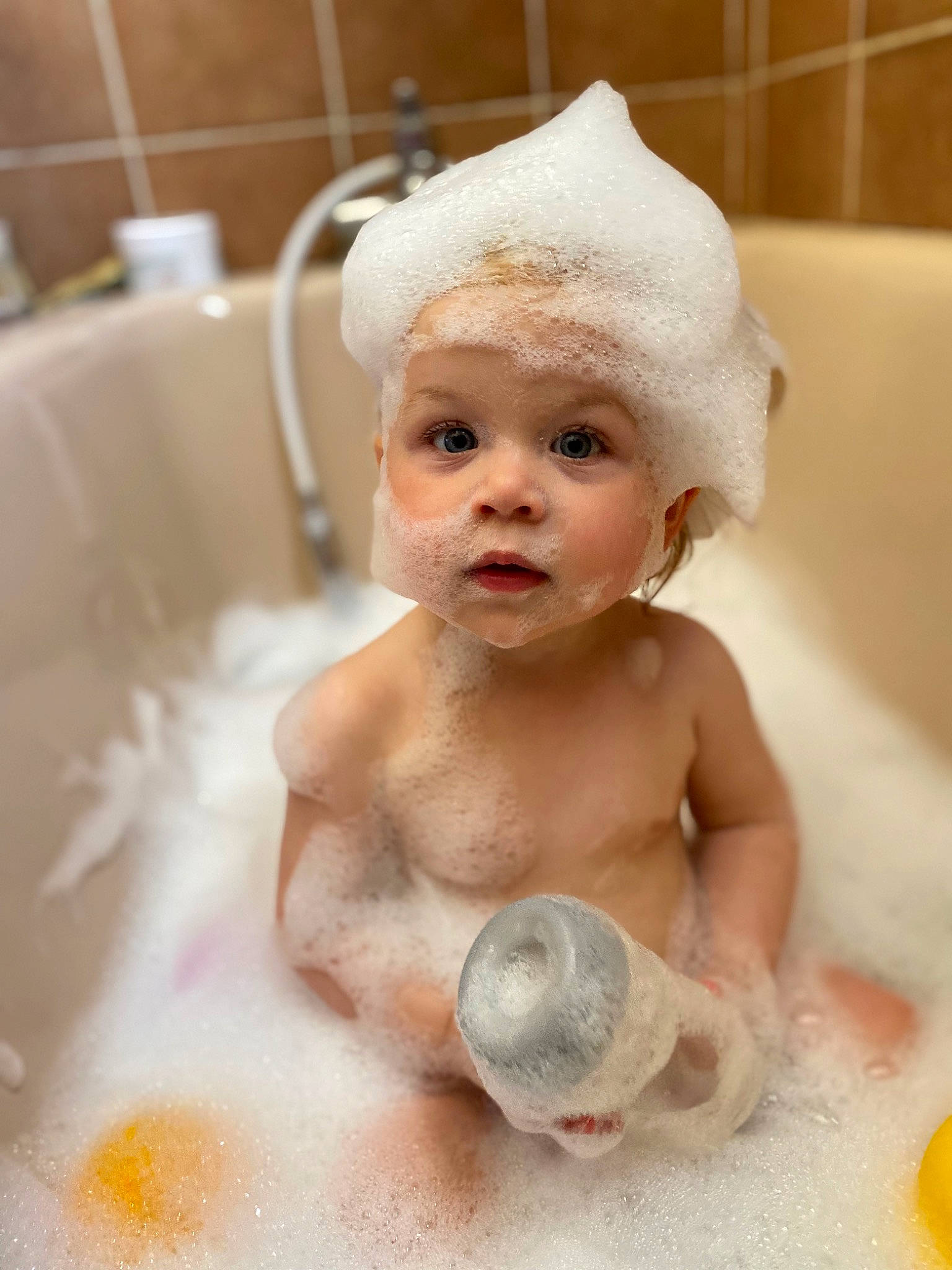 Héloïse participe au concours pour gagner de l'argent avec cette photo : baby, baby_bathing, bathing, bathroom, bathtub, cap, chest, child, flooring, foam, fun, happy, headpiece, headwear, person, plumbing, plumbing_fixture, skin, smile, thumb